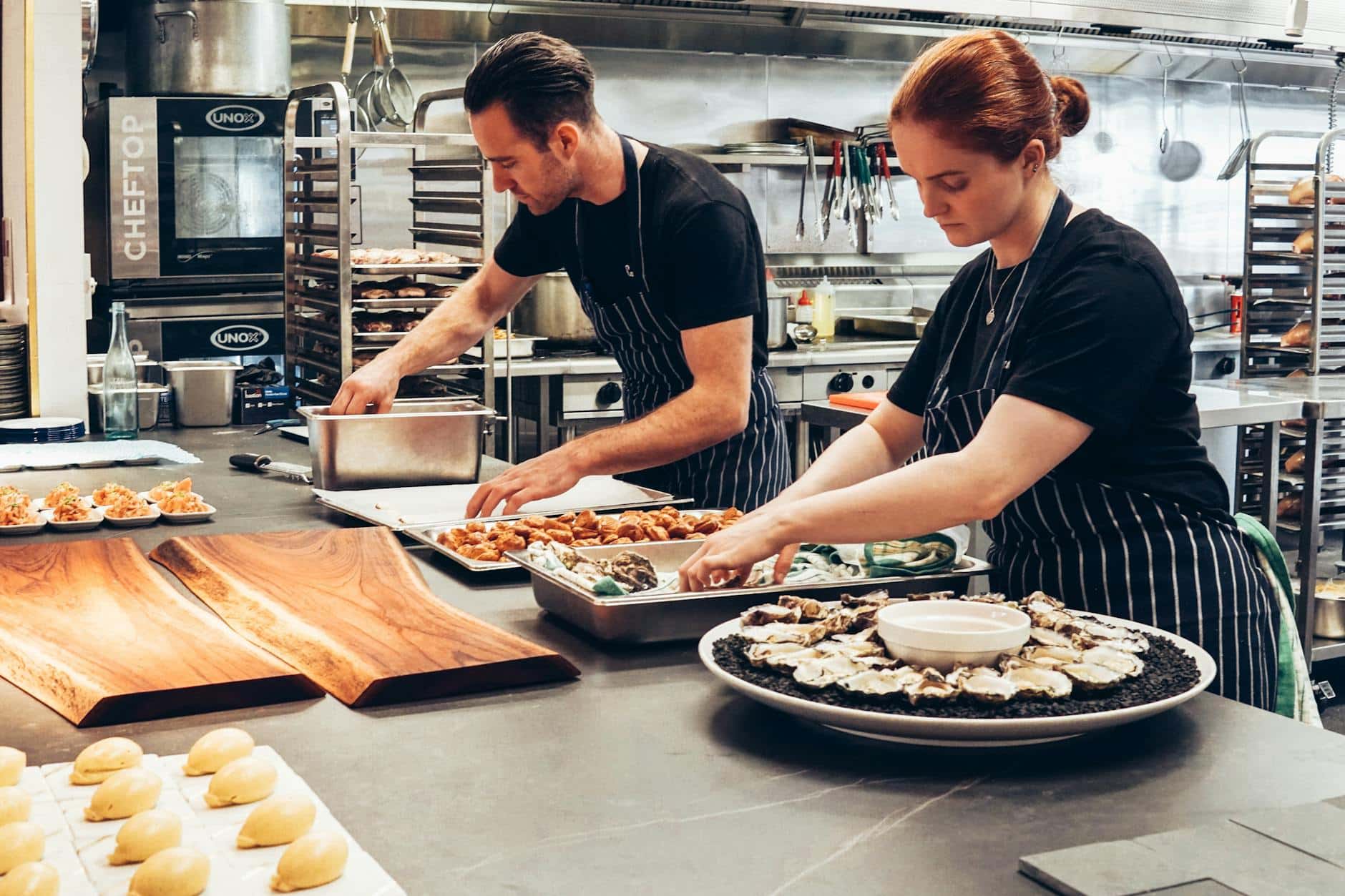 man and woman wearing black and white striped aprons cooking
standard of living 