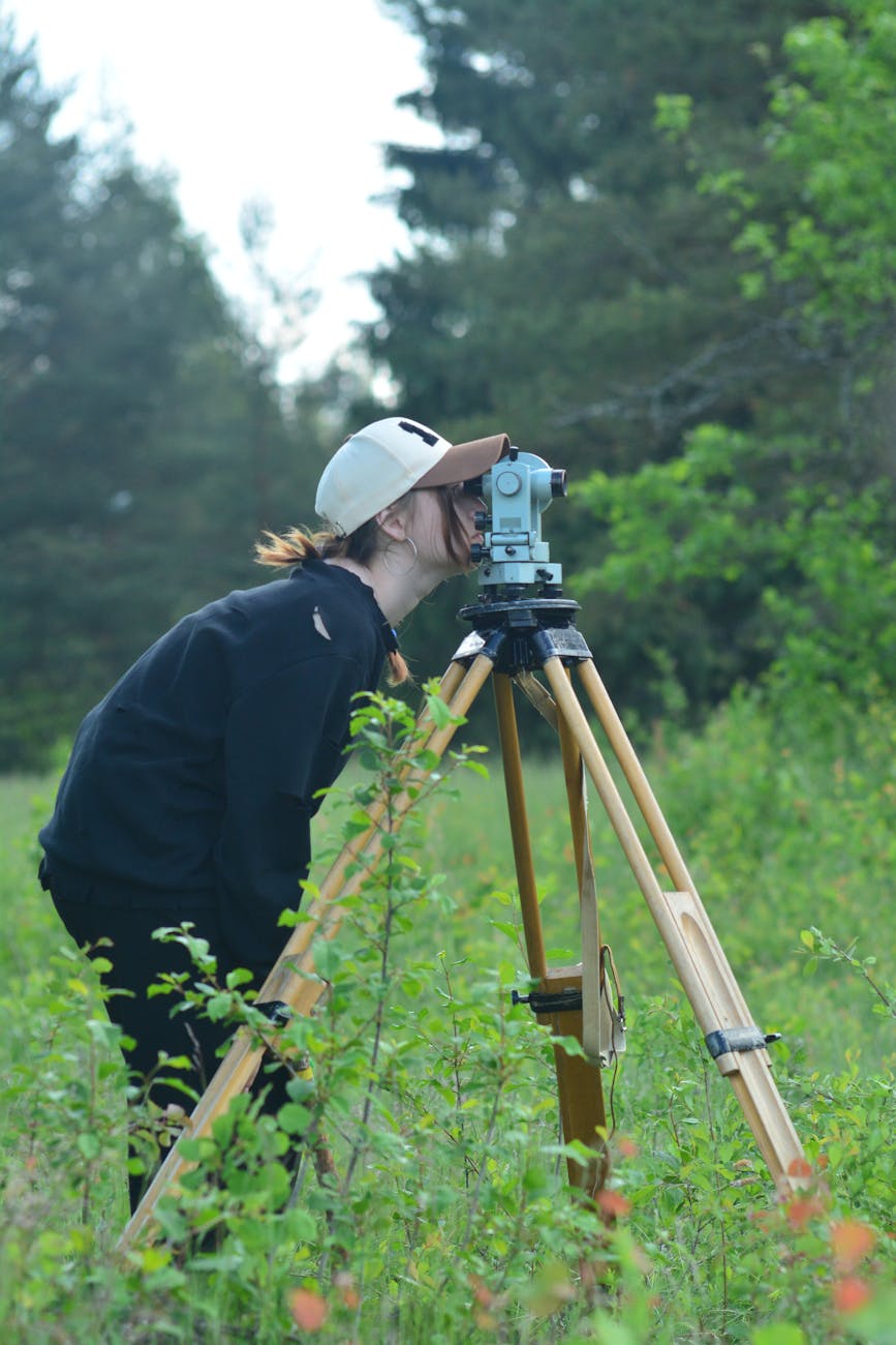 surveyor using theodolite in scenic outdoor setting